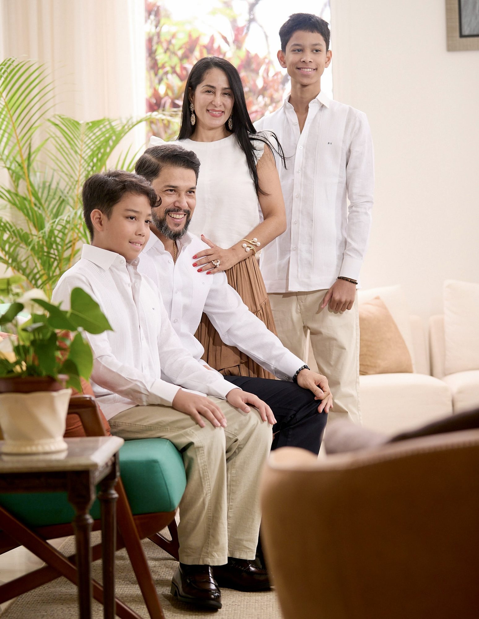 Família diplomática em retrato caloroso em casa, todos de branco
